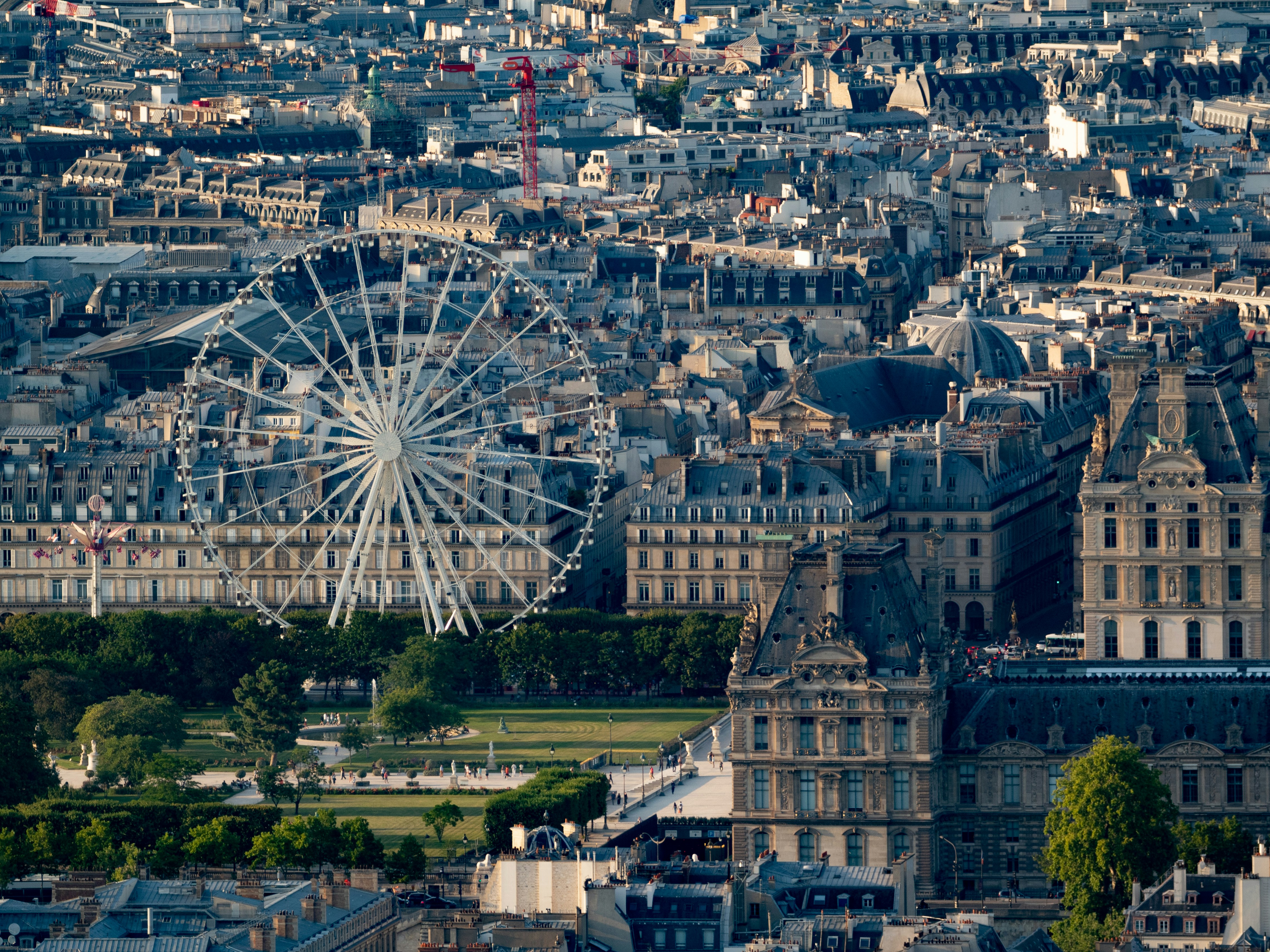The eiffel tower and ferris wheel can be seen., 