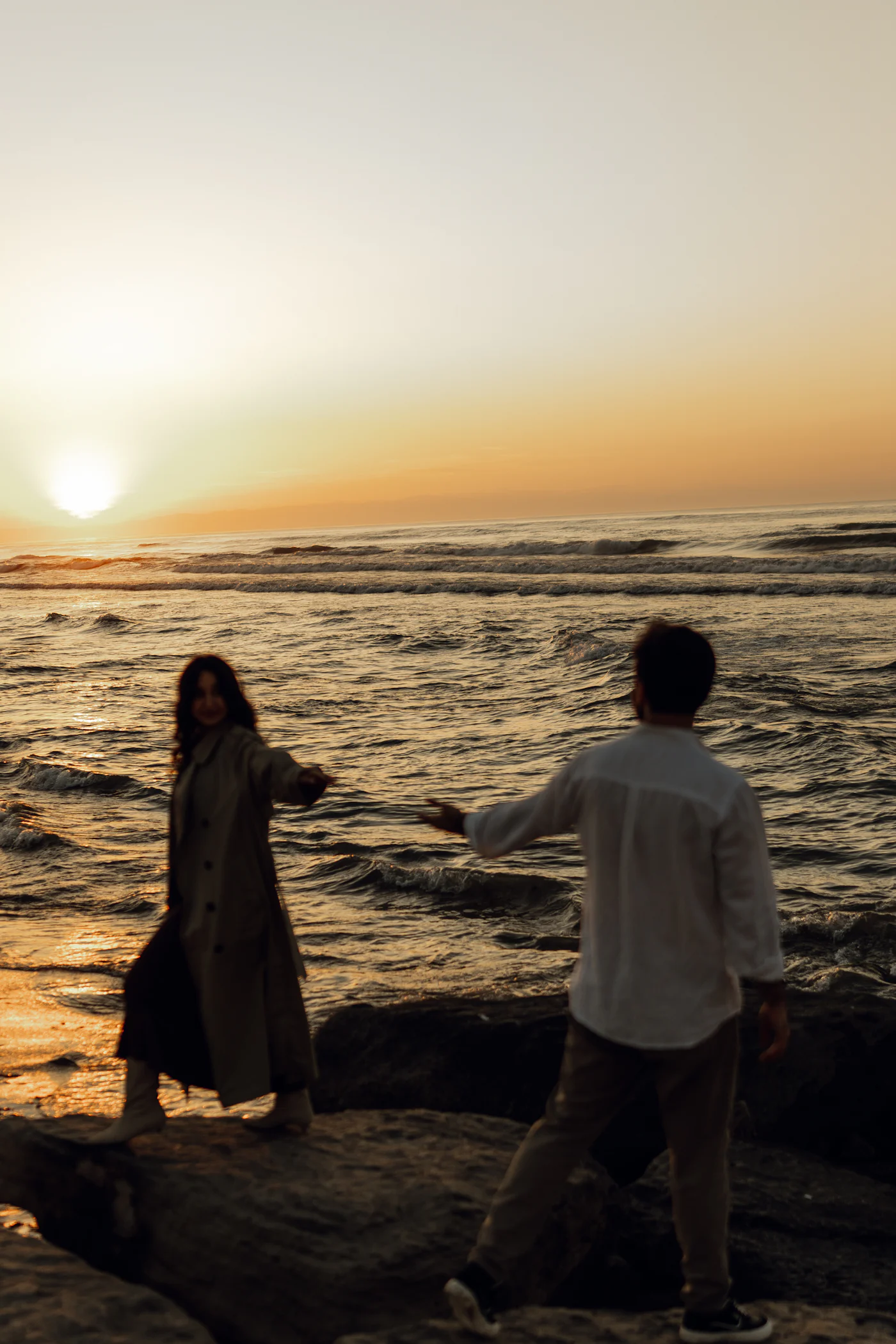 Mara y Tomás juntos frente al mar al atardecer