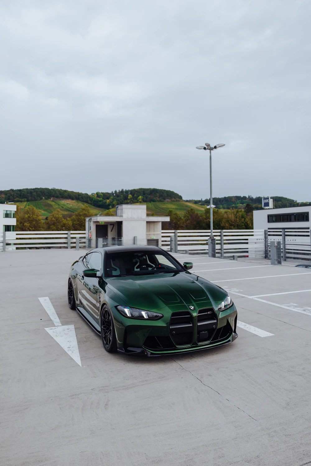 Green BMW M4 photographed on a rooftop