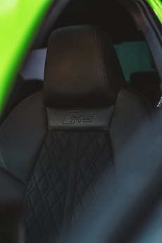 Black leather car seat with "rs" insignia.