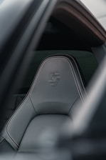 Porsche seat features stitching and logo detail.