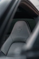 Porsche seat features stitching and logo detail.