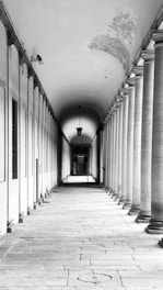 A long, columned corridor in black and white.