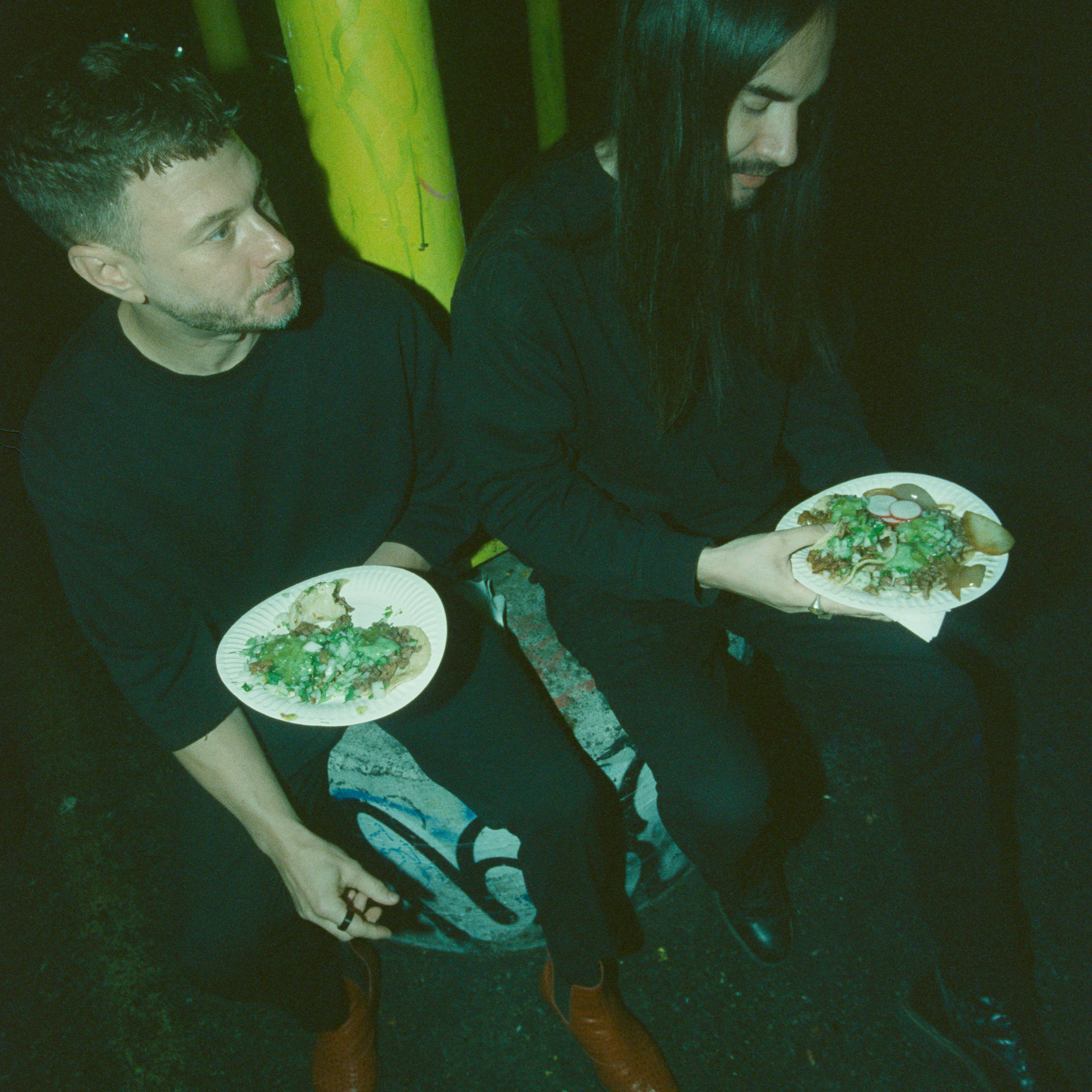 Two people enjoy food in the dark.