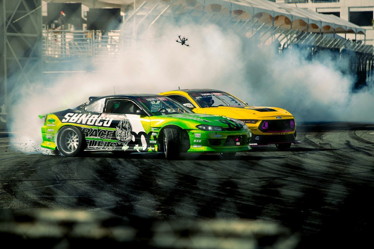 Two cars battle through a corner during a professional drift competition