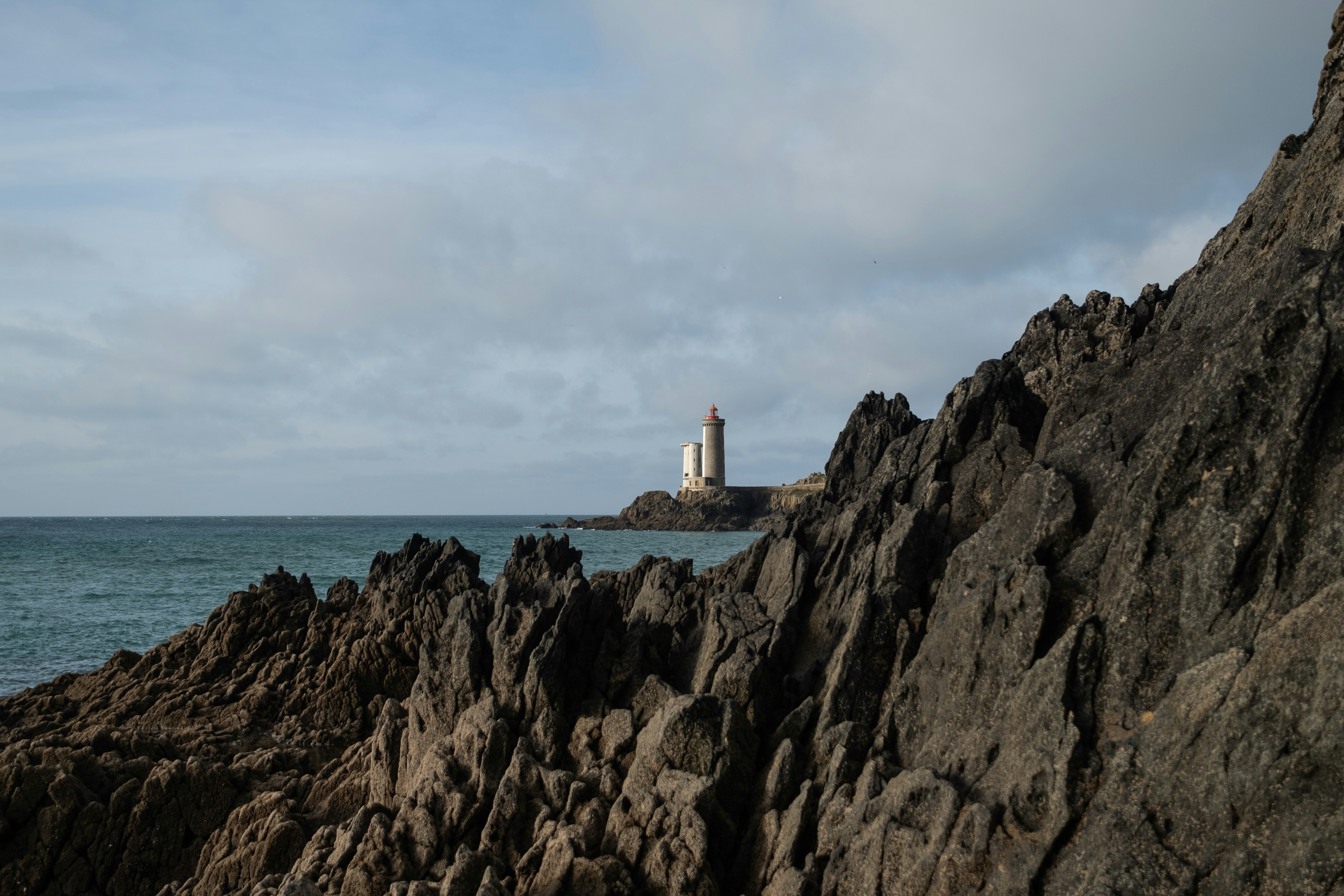 Un faro si trova vicino a una costa rocciosa.