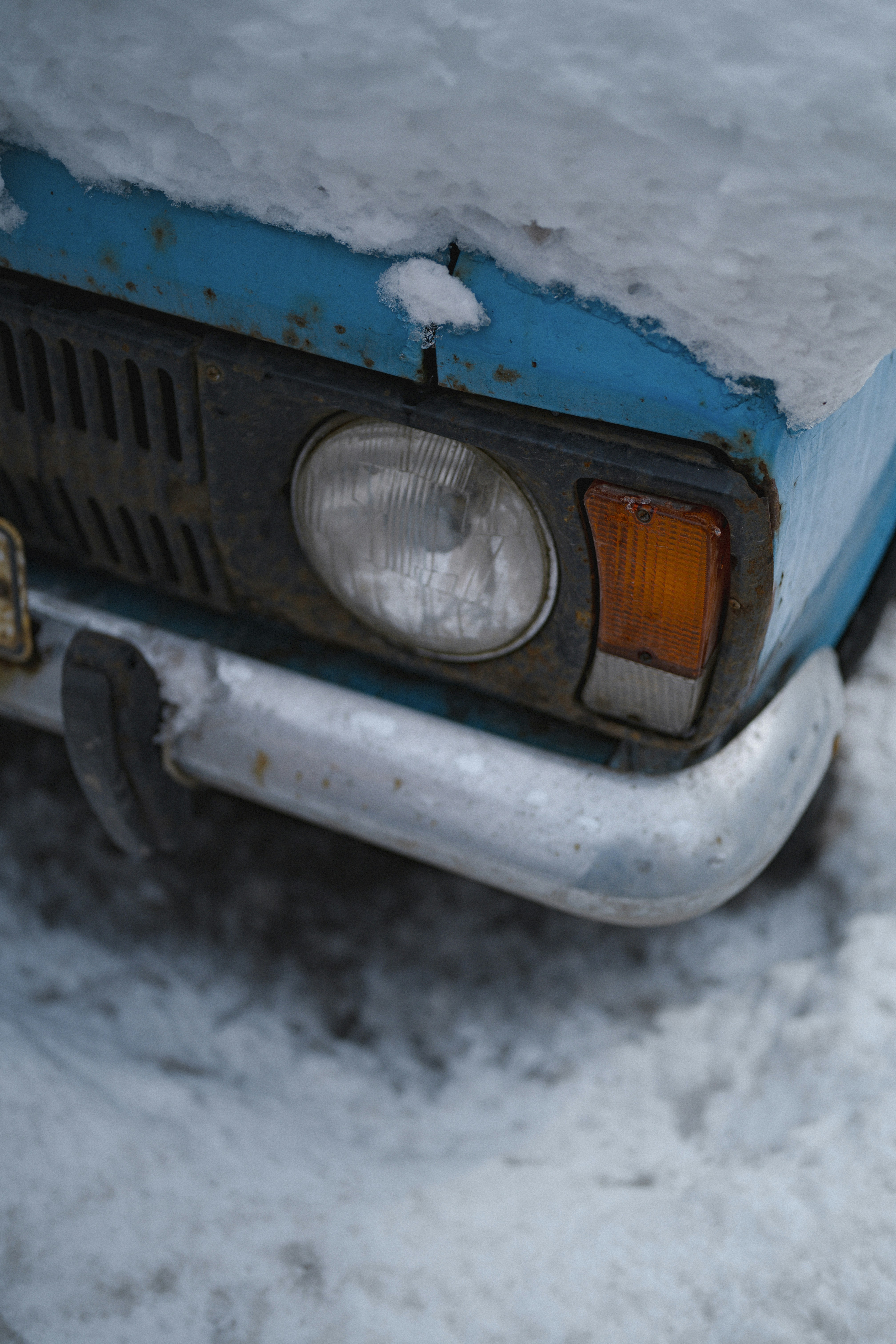 A blue car covered in snow.