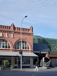 A pedestrian crosses a street near a marketplace.