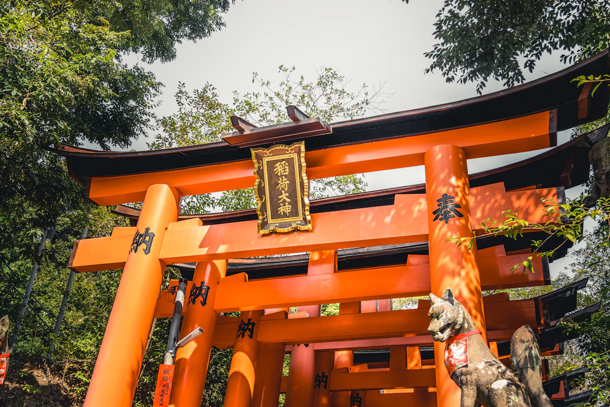 Orange torii gate standing at a traditional Japanese shrine surrounded by greenery