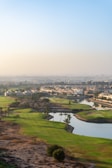 Golf course with a scenic view of a city.