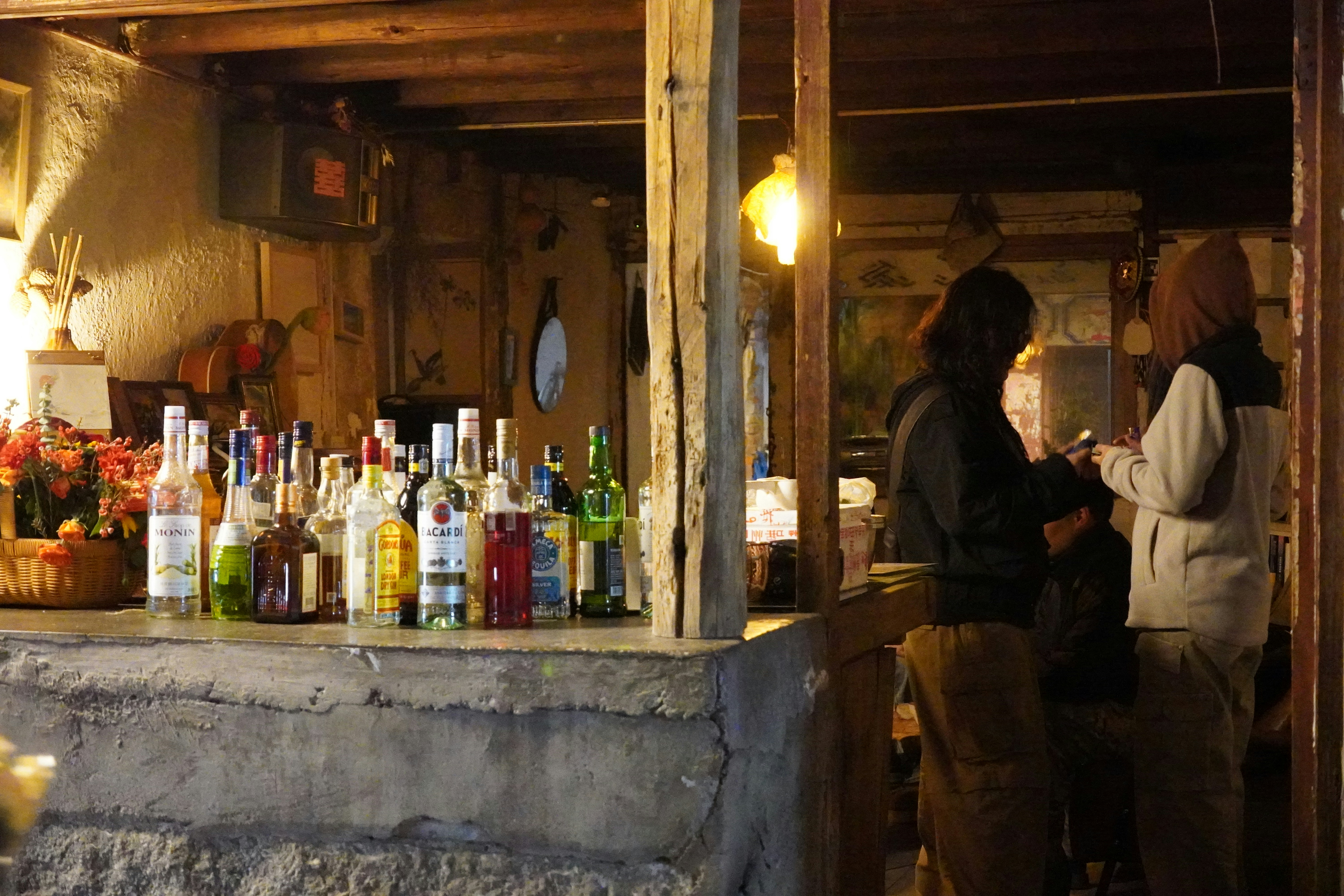 People at a rustic bar with drinks.