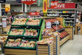 Apples and other produce are displayed in a supermarket.