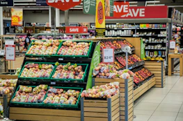 Apples and other produce are displayed in a supermarket.
