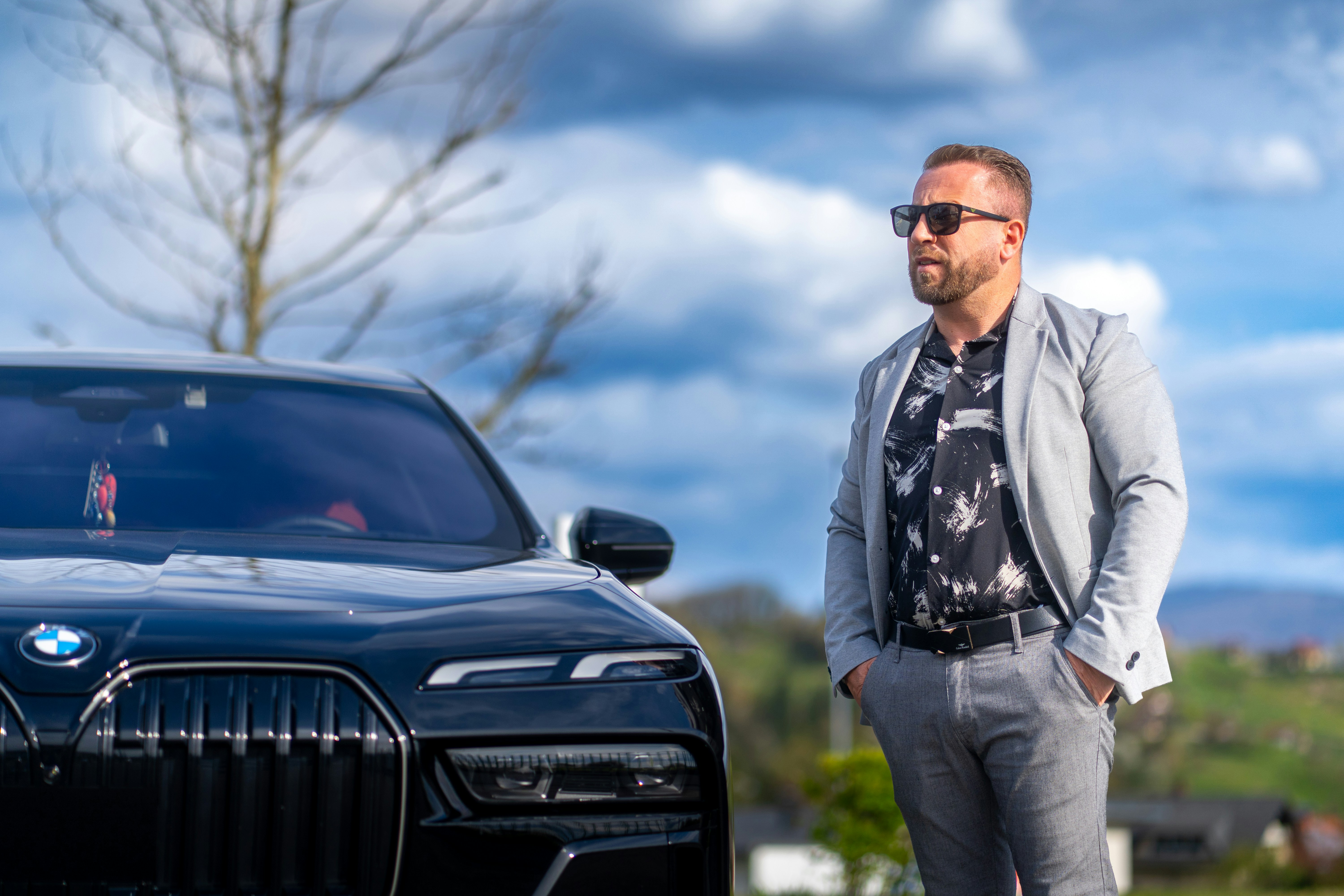 Man poses next to a sleek black bmw.