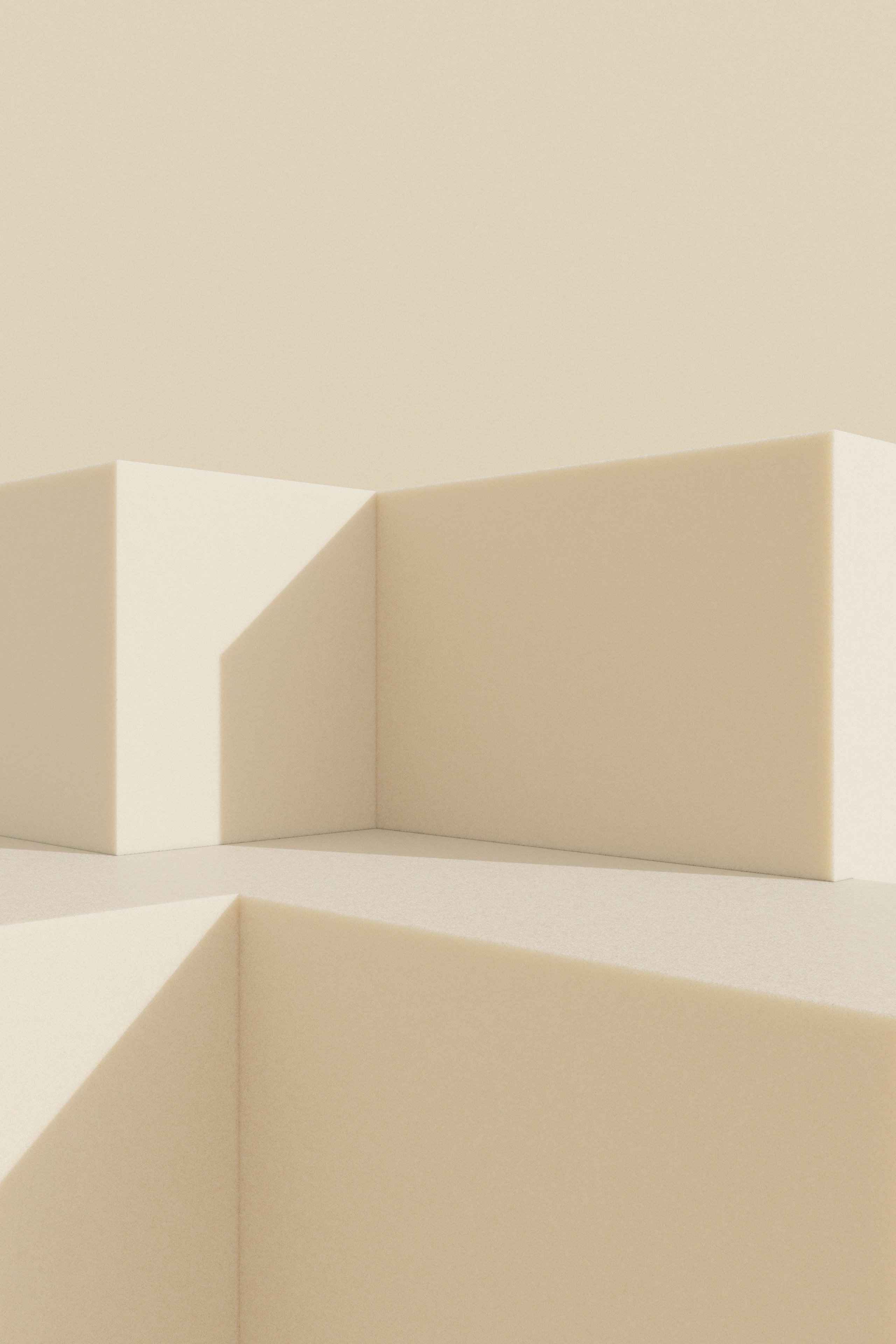 Soft planes of warm plaster meeting at a corner, lit by low raking light.