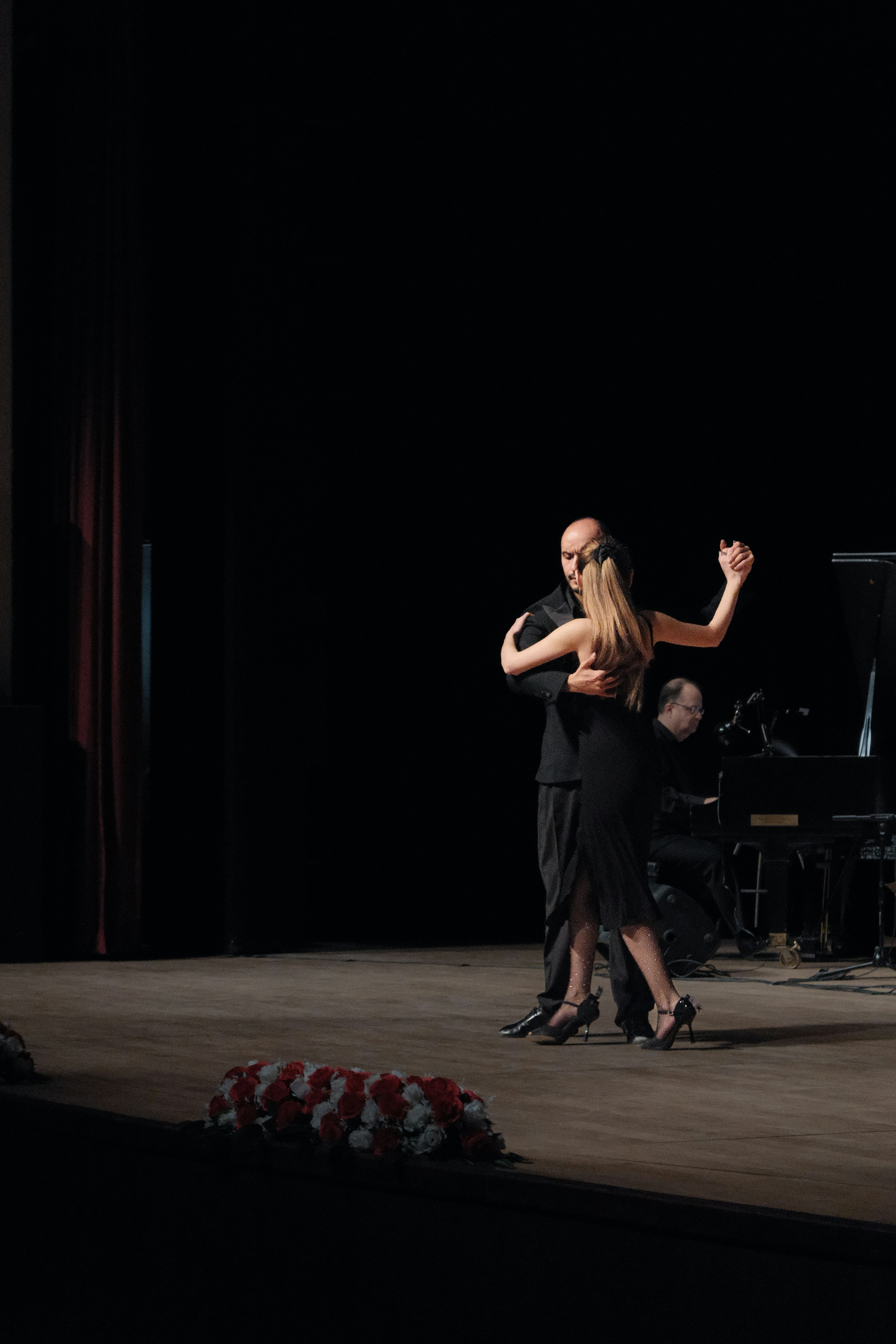 A couple dances the tango on a stage.