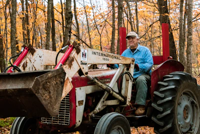 A man drives a tractor through the forest
