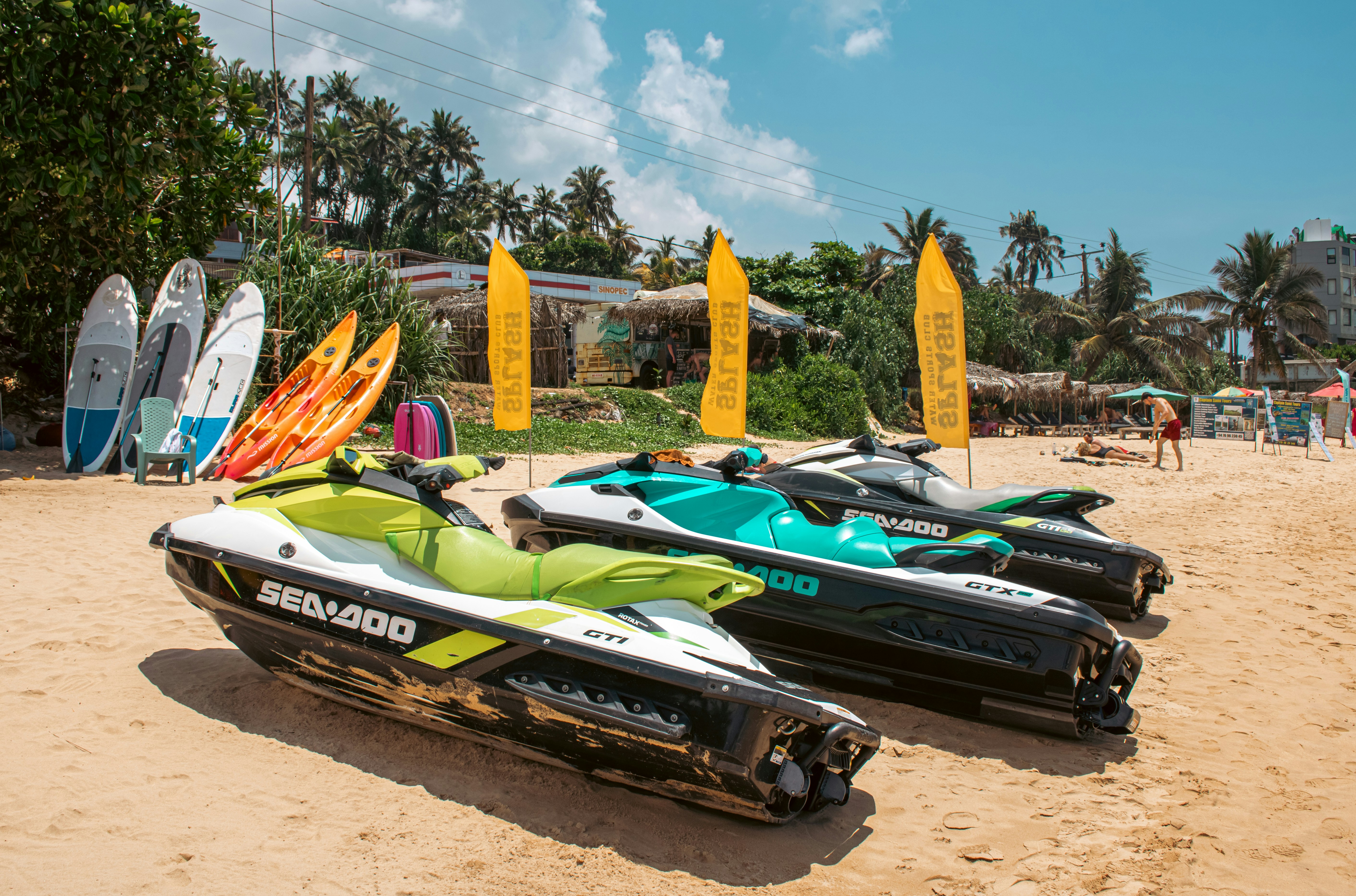 Jet skis and other water sports equipment on a beach.
