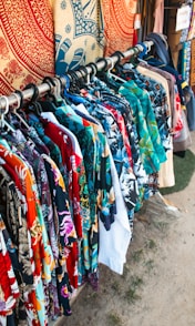 Shirts with colorful patterns hang on a rack.