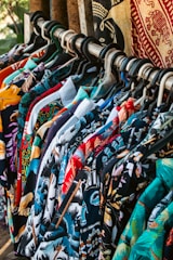 Shirts with colorful patterns hanging on a rack.
