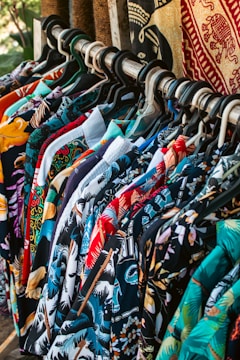 Shirts with colorful patterns hanging on a rack.