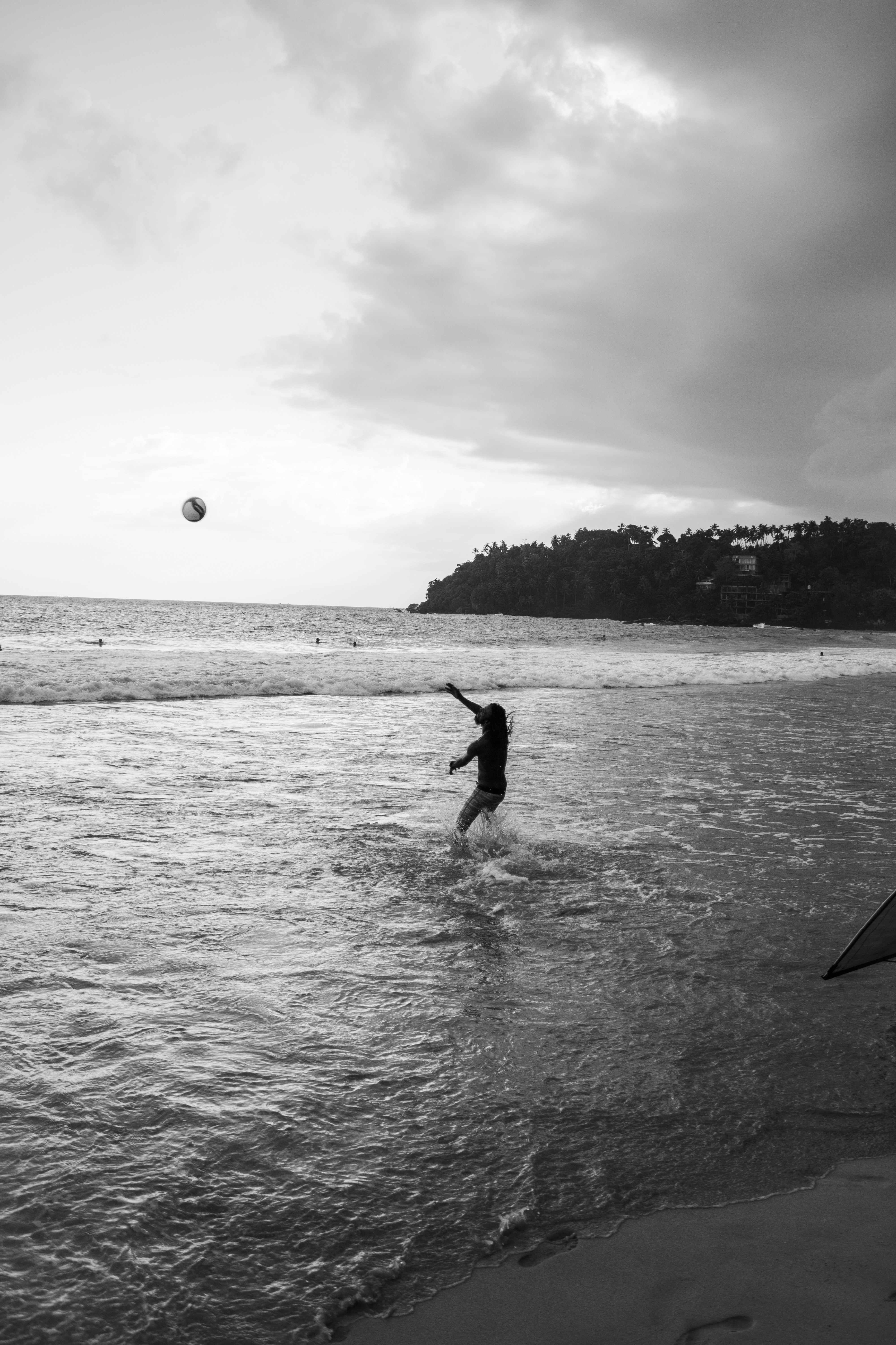 Alguém brinca com uma bola na praia.