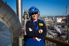 Woman engineer smiles, working in a plant.
