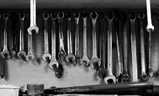 Wrenches hang on a wall in a workshop.