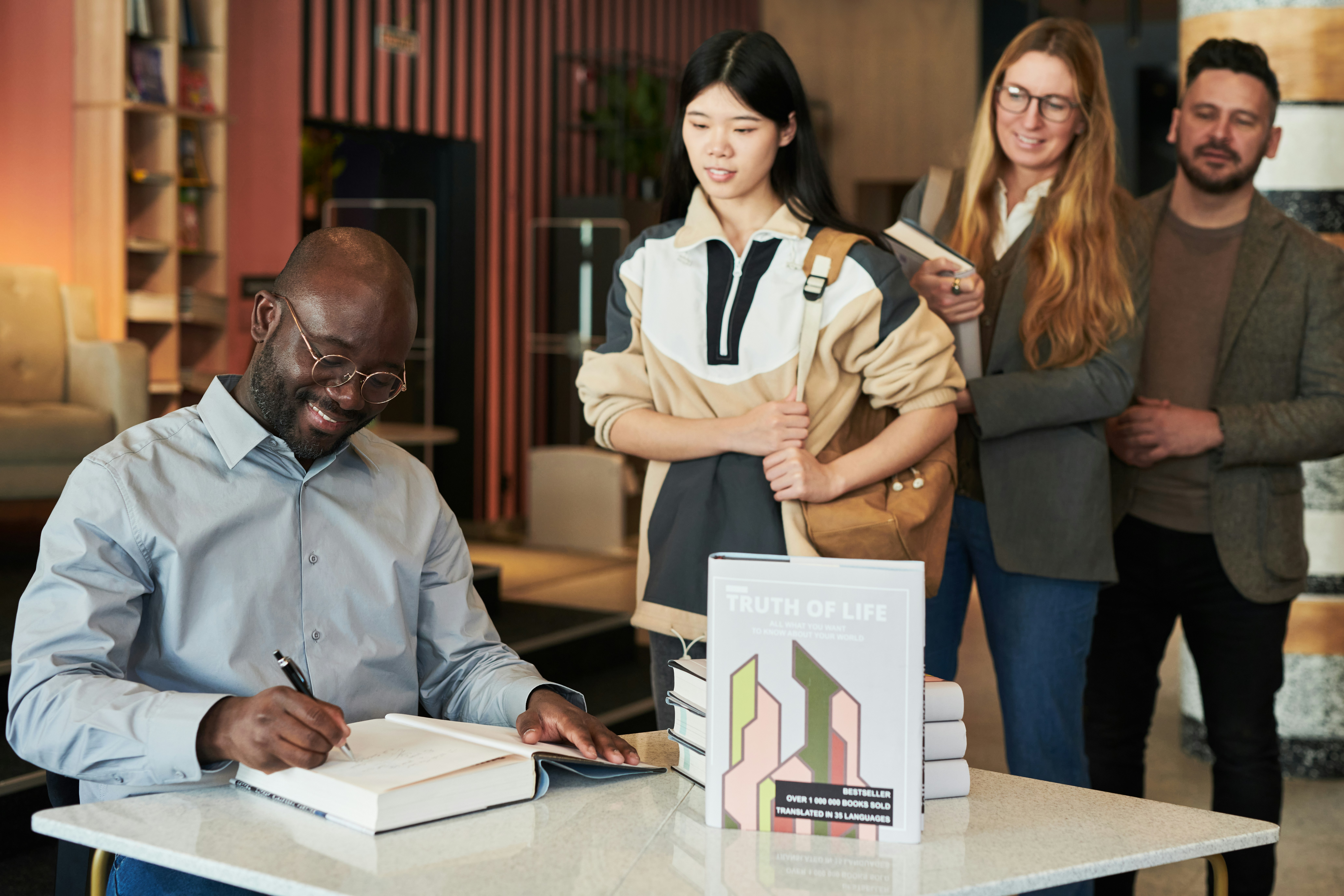 Author signs a book for waiting fans.