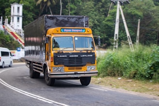 A yellow truck drives on a road.
