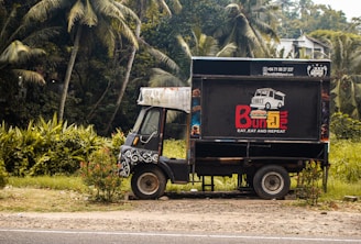 A food truck parked in front of some trees.
