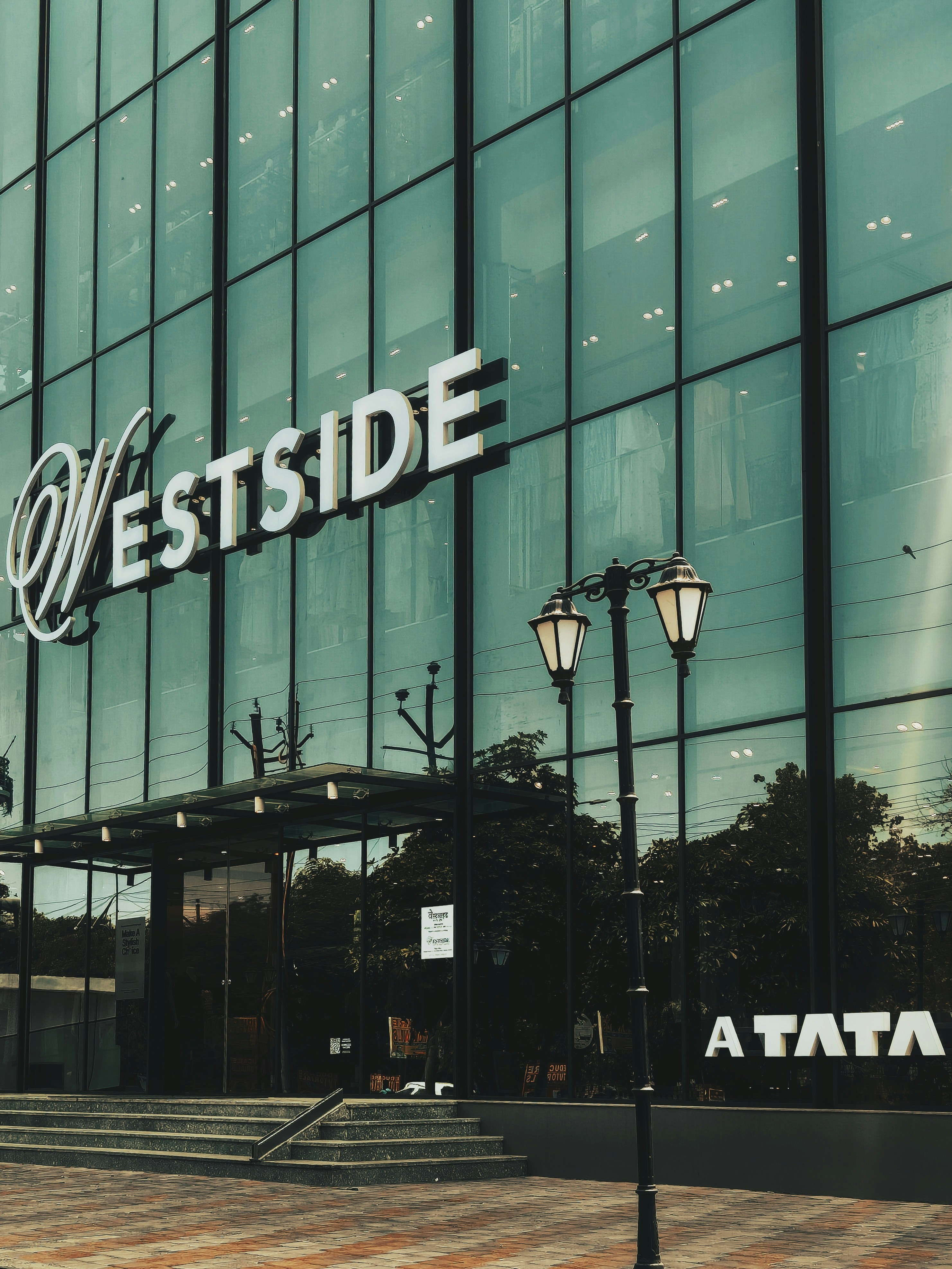 Westside store facade with a three-lamp post.