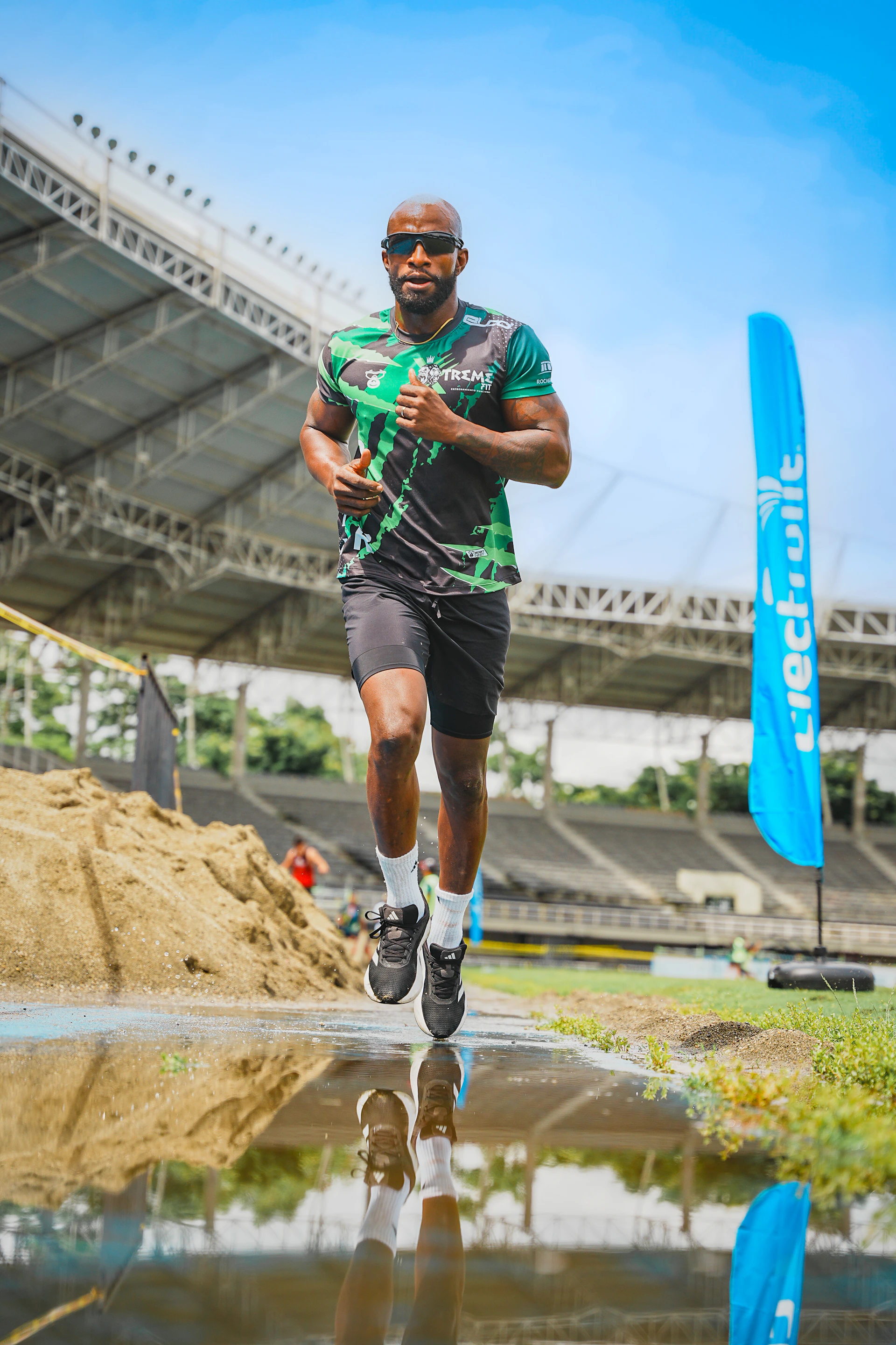 Athlete runs across puddle towards the camera.