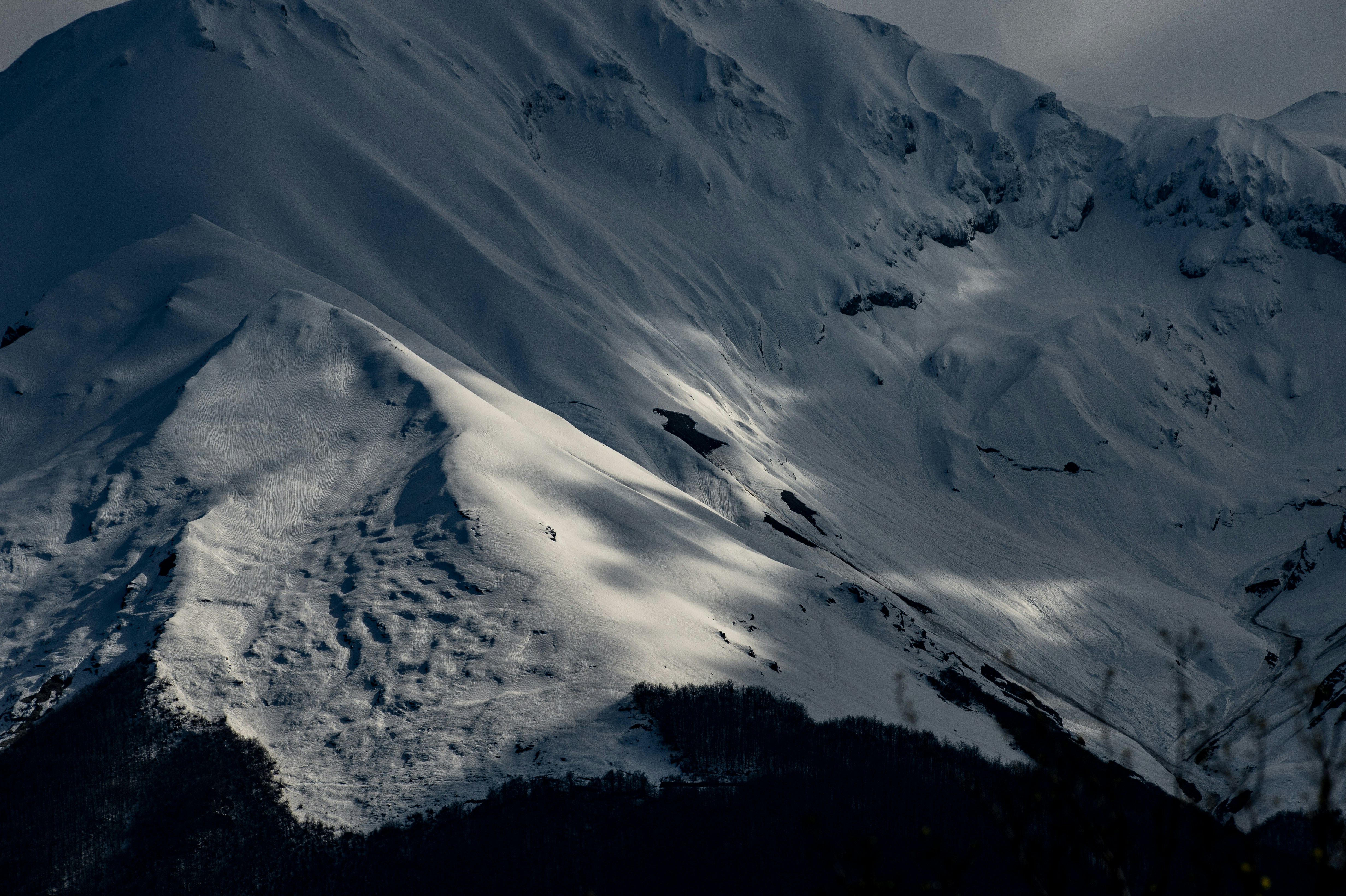 Snowy mountainside with dramatic shadows.
