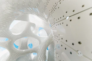 Abstract, white structure with holes and panels.