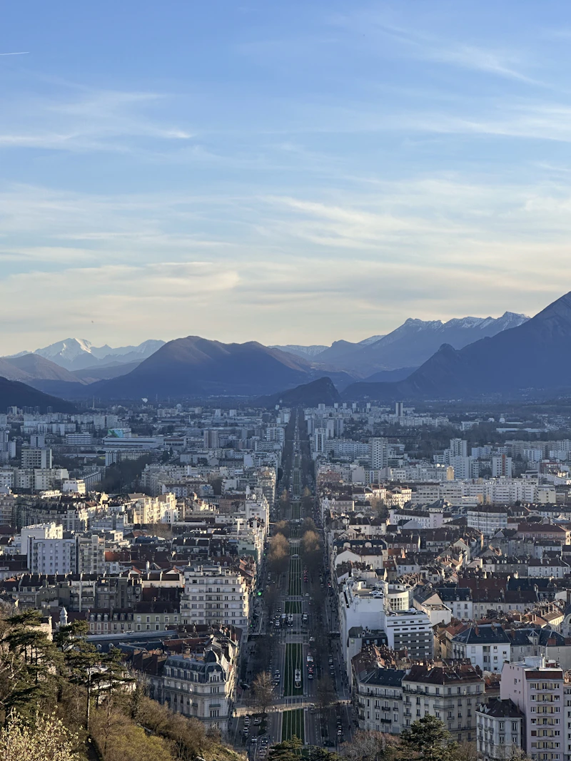 Vue sur Grenoble depuis les hauteurs, les massifs en arrière-plan