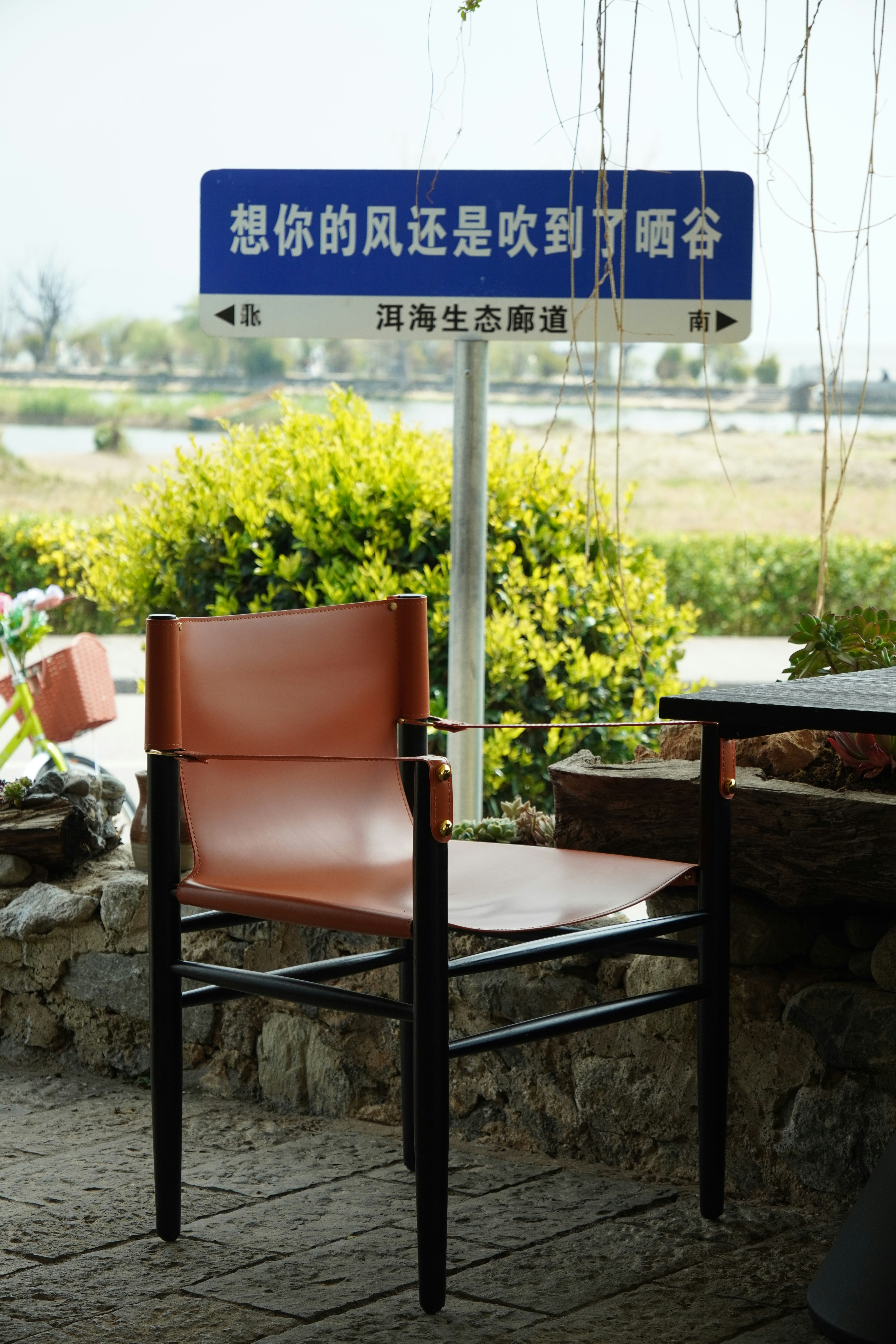 An empty chair sits near a signpost outdoors.