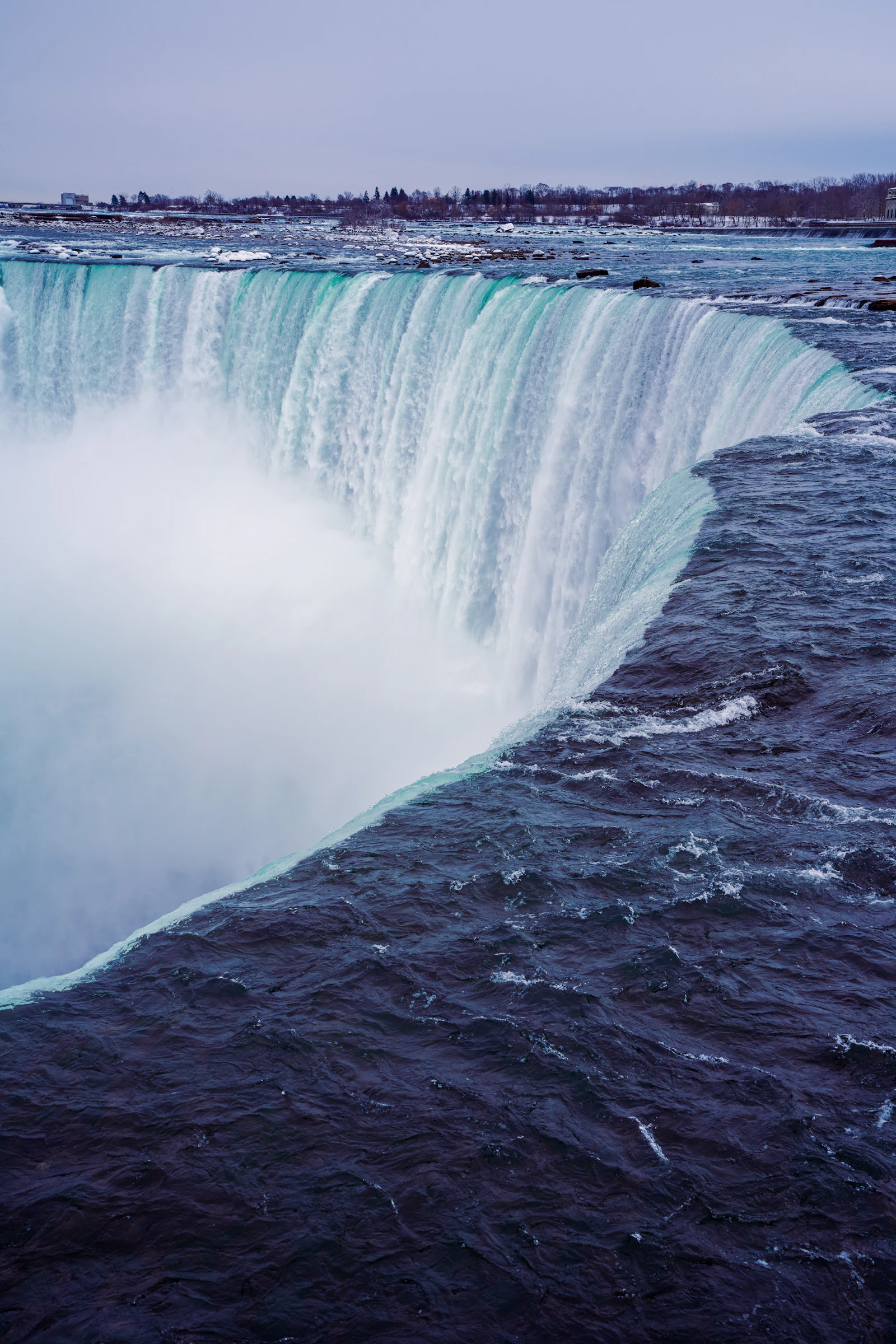 Close-up of Niagara Falls, Ontario, with water cascading powerfully over the edge into mist