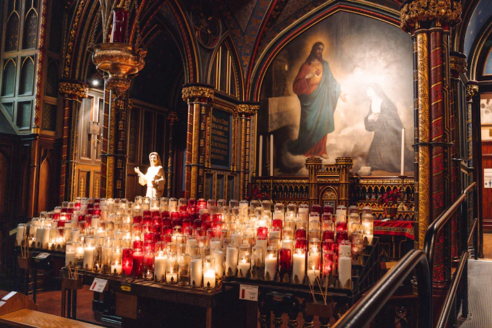 Candles illuminate a church interior with an icon.