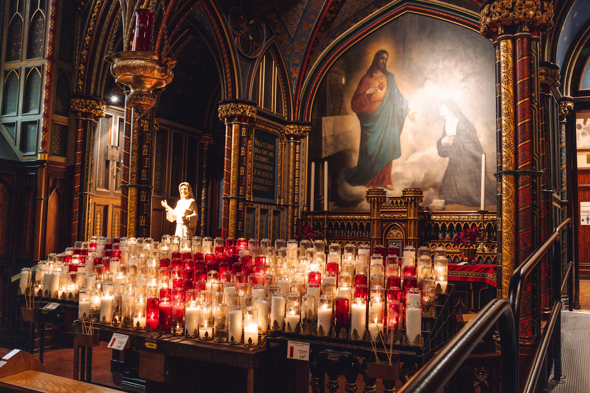 Hundreds of votive candles glowing before a Madonna painting in a gothic church