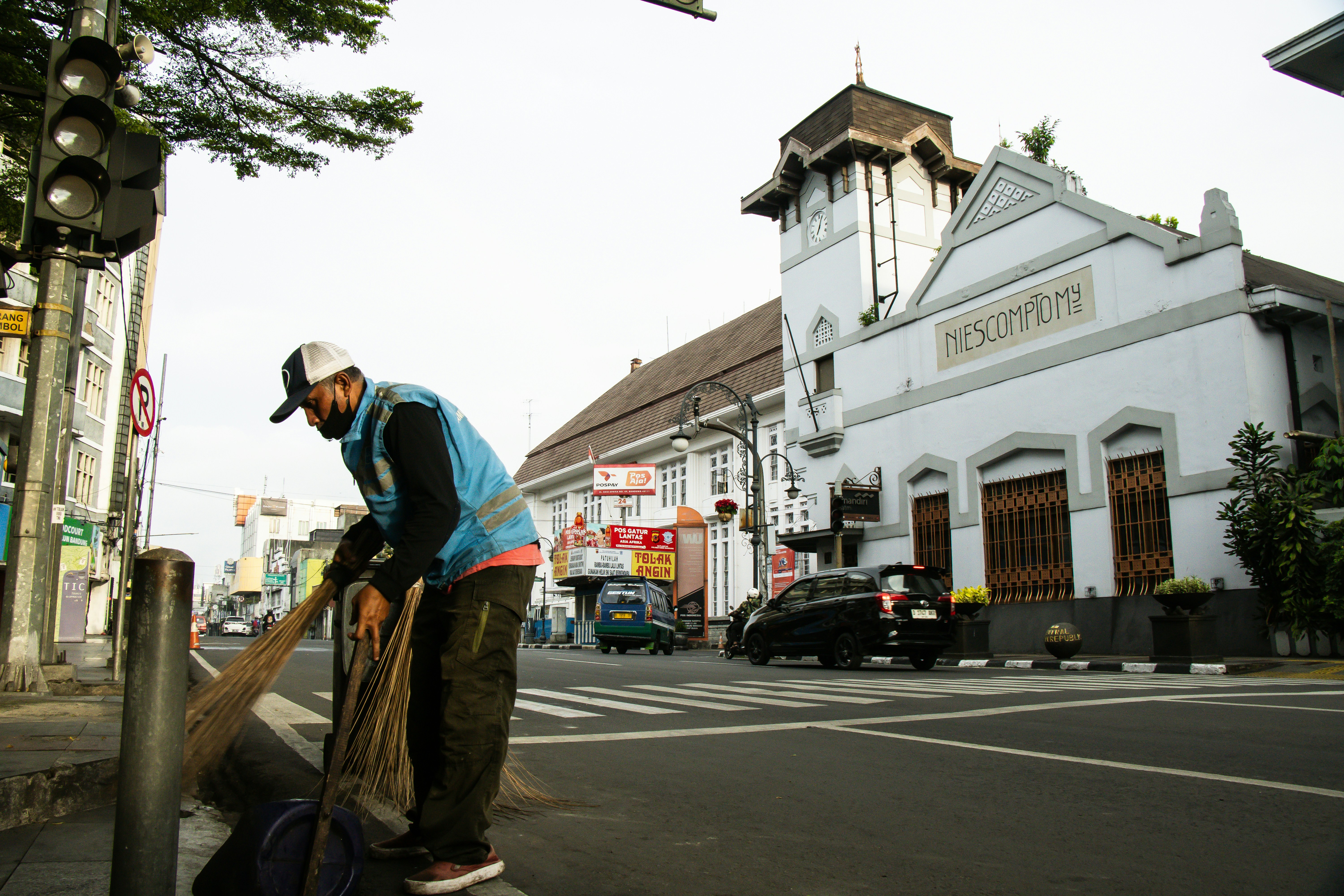 A street sweeper cleans near a beautiful building.