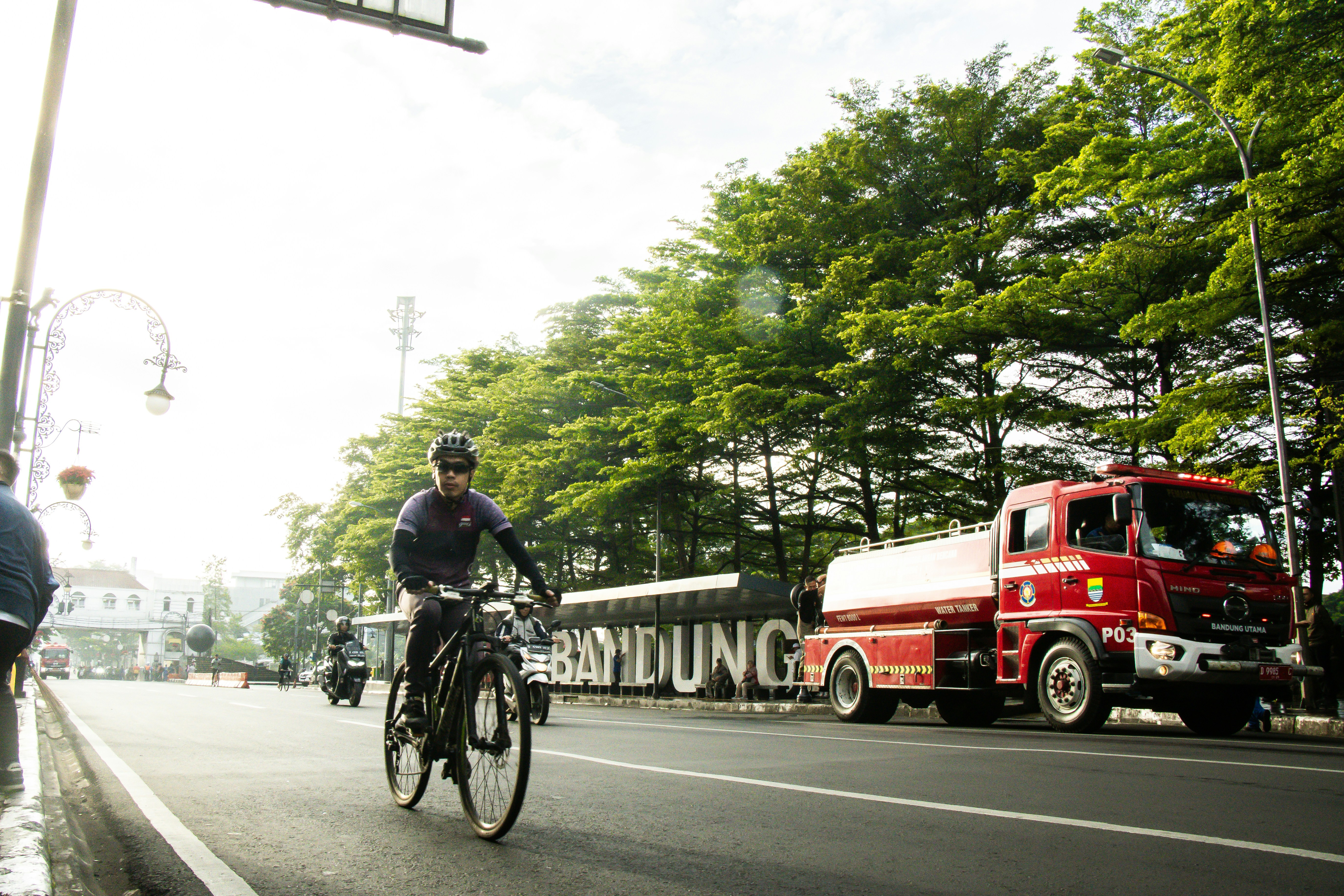 Seorang pengendara sepeda dan truk pemadam kebakaran di Bandung, Indonesia.