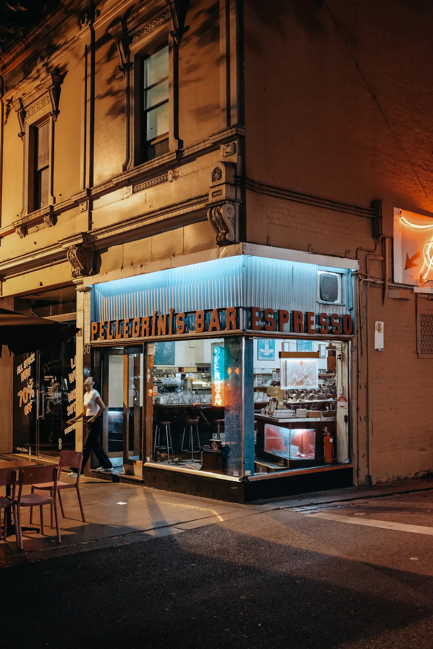Espresso bar glowing on a city laneway at night