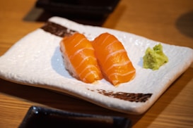 Salmon nigiri sushi presented with wasabi.