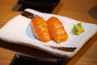 Salmon nigiri sushi presented with wasabi.
