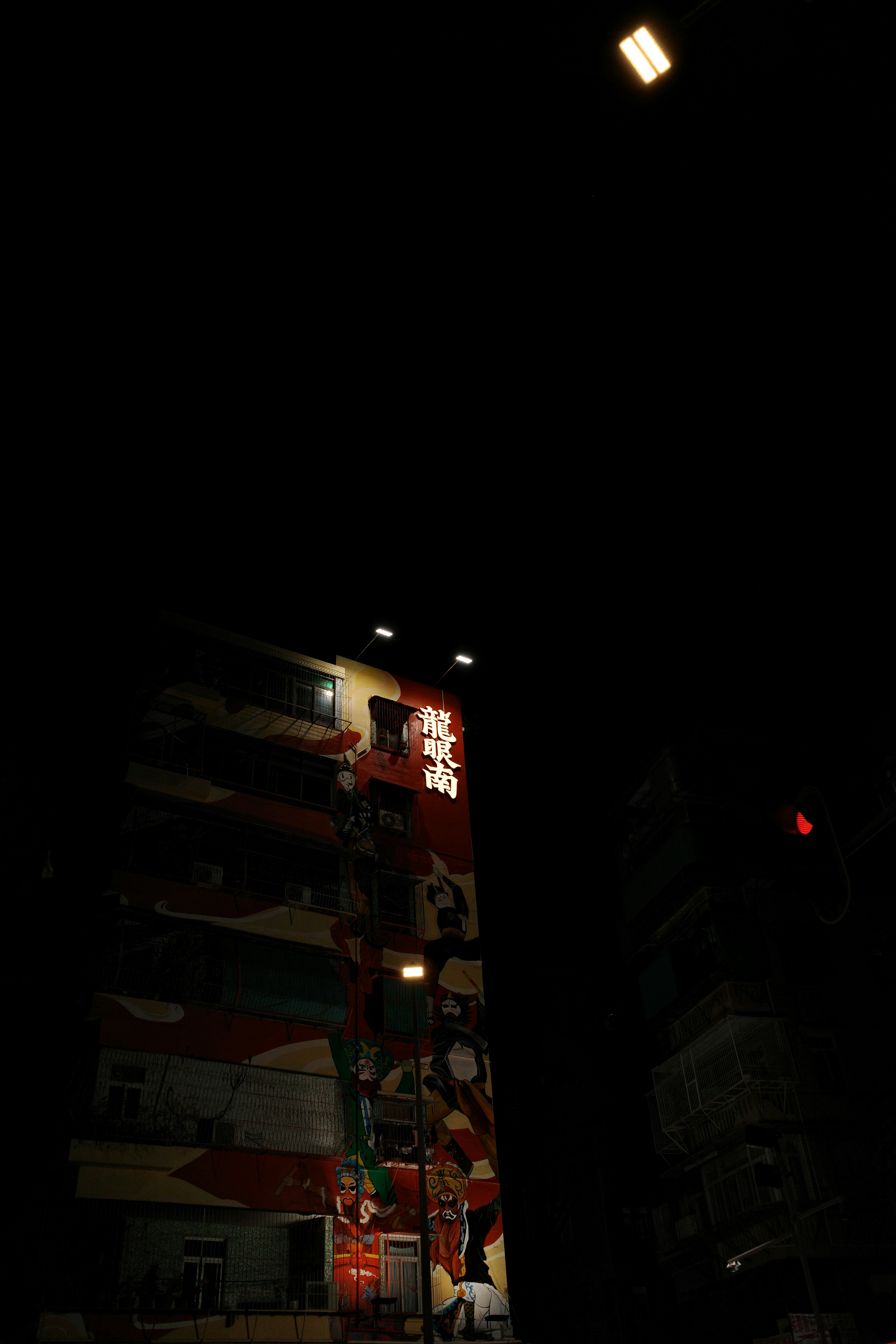 A building with a colorful mural at night.