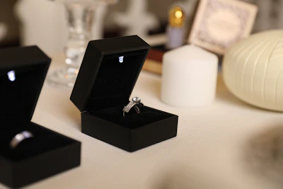 Engagement rings sit in open black boxes.