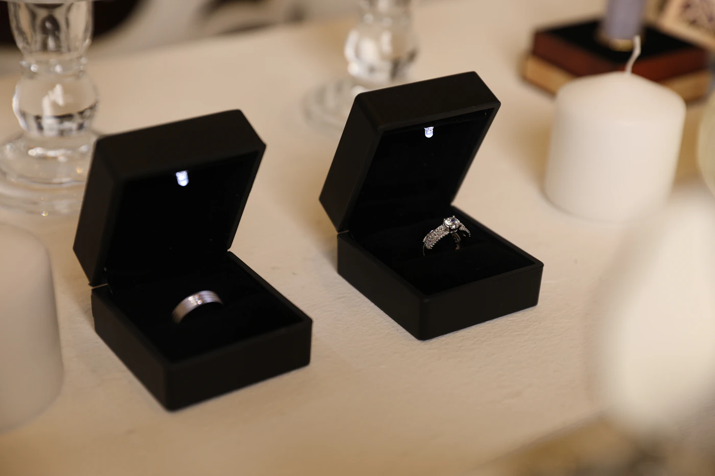 Two wedding bands in open black ring boxes