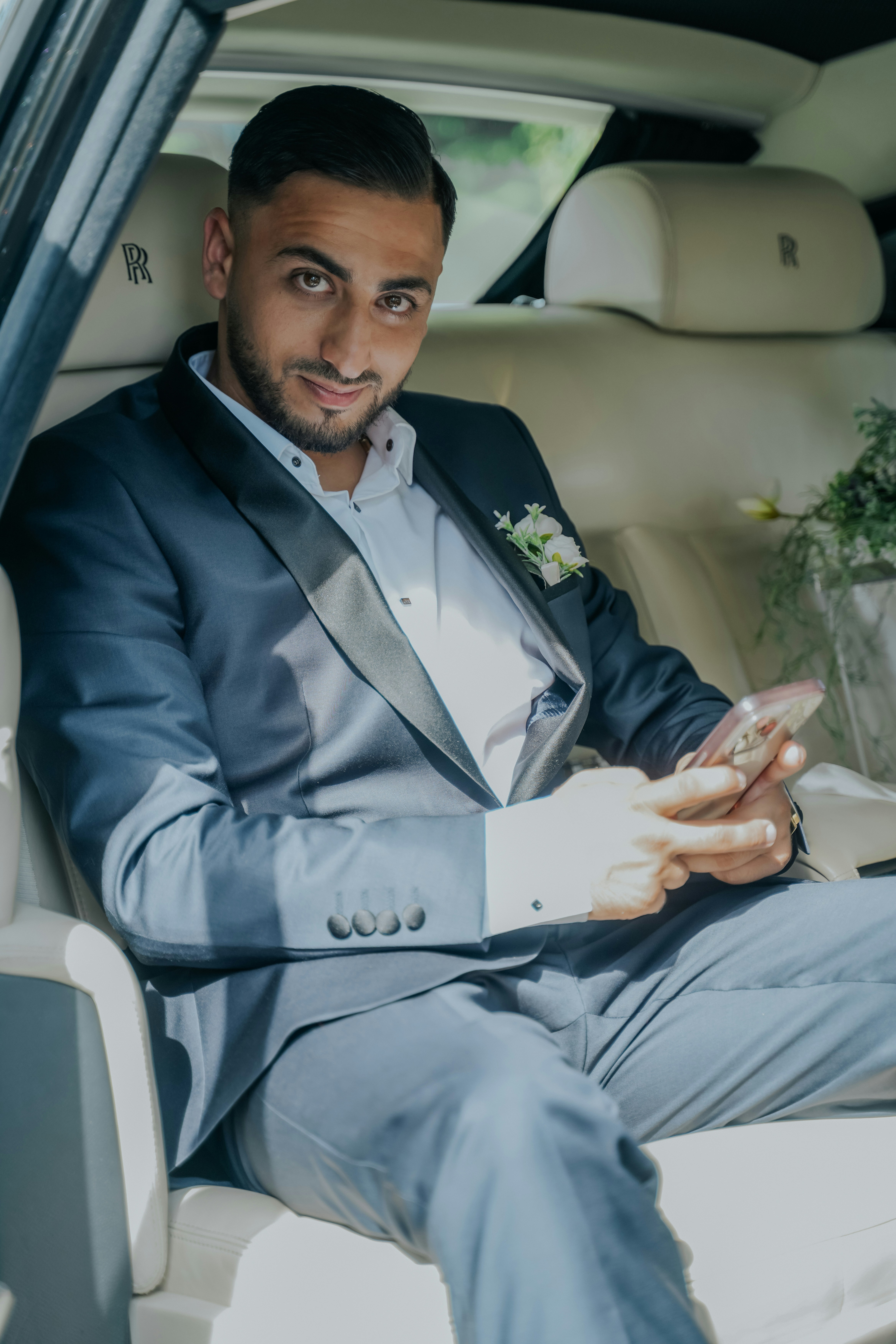 Handsome man in a suit sits in a car.