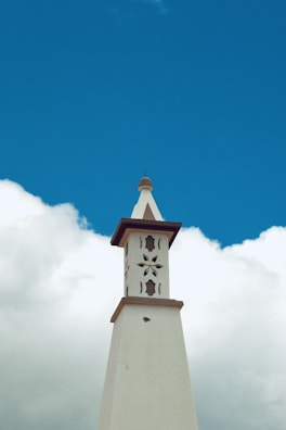 Tower against a bright blue sky and clouds.